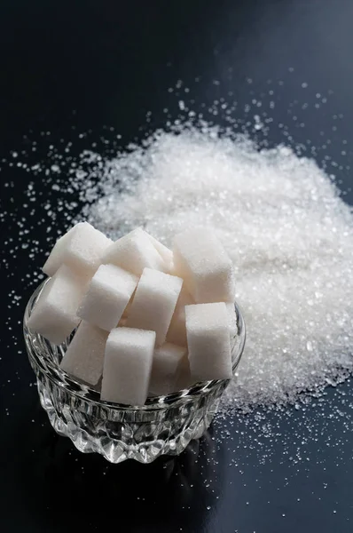 Azúcar granulado blanco y azúcar refinada primer plano sobre fondo negro — Foto de Stock