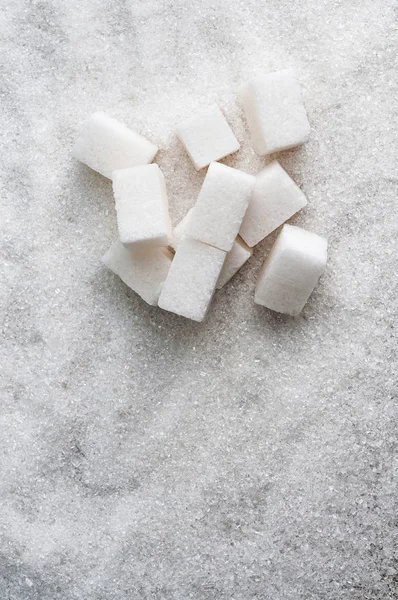 Azúcar como fondo y cubos de azúcar blanco — Foto de Stock