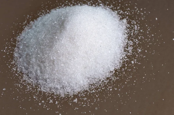 Sterty granulowany cukru białego na szary powierzchni. Szczelnie-do góry — Zdjęcie stockowe