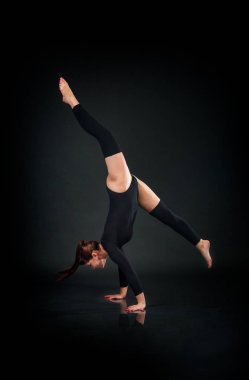 koyu arka plan atletik beceri gösterilen kadın jimnastikçi