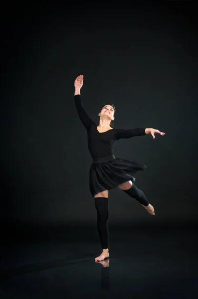 Bela dançarina de balé feminina dançando no fundo preto — Fotografia de Stock
