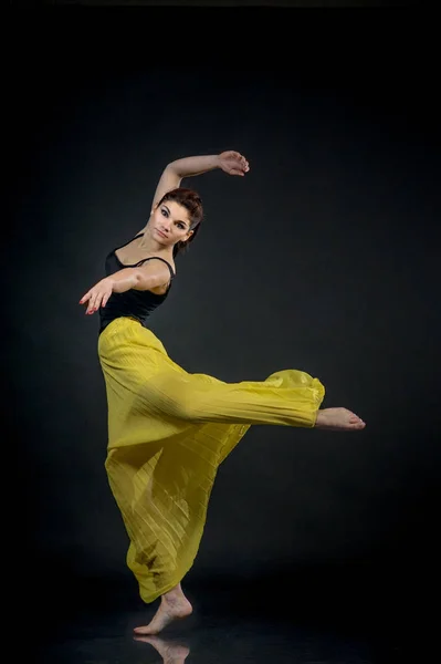 Jovem dançarina saltando contra fundo preto — Fotografia de Stock