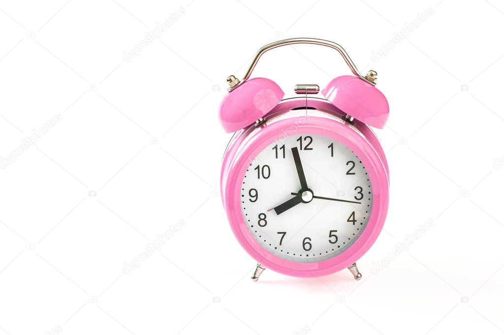 Retro pink alarm clock, with 2 minutes to 8 o'clock on it. Isola