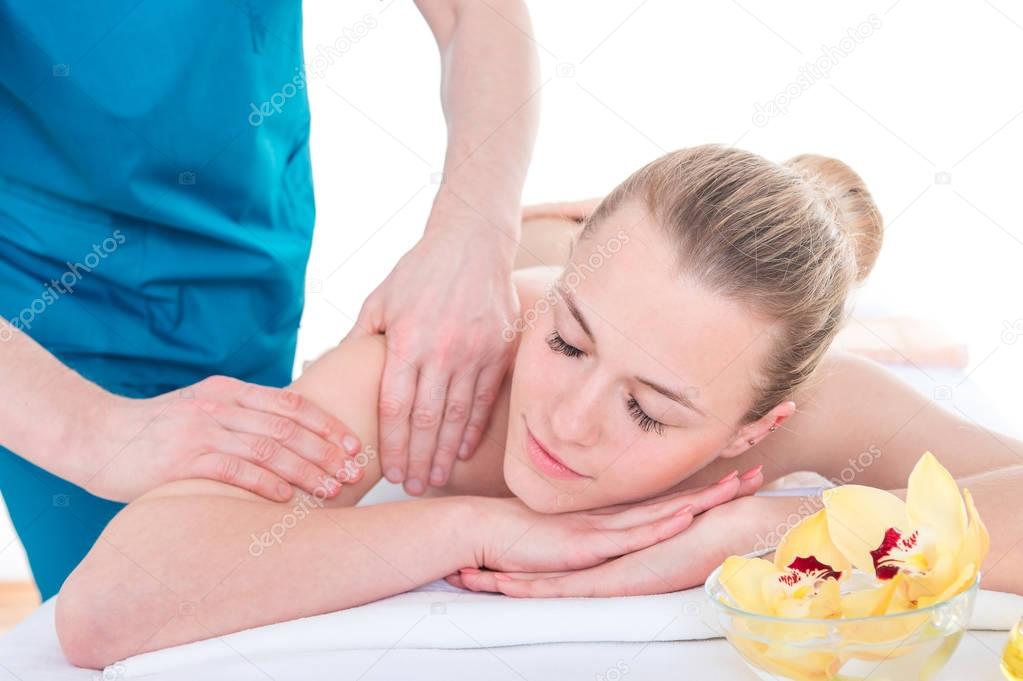 Professional masseur massaging female shoulder and arms. Relaxin
