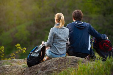 güzel çift sırt çantaları ile yaz orman arka plan üzerinde eğleniyor.
