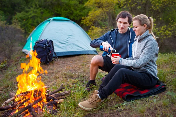 Pareja Viajeros Descansando Con Una Taza Junto Fuego Tiendas Campaña —  Fotos de Stock