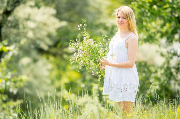 아름 다운 젊은 임신 wildflo의 꽃다발과 함께 휴식 — 스톡 사진