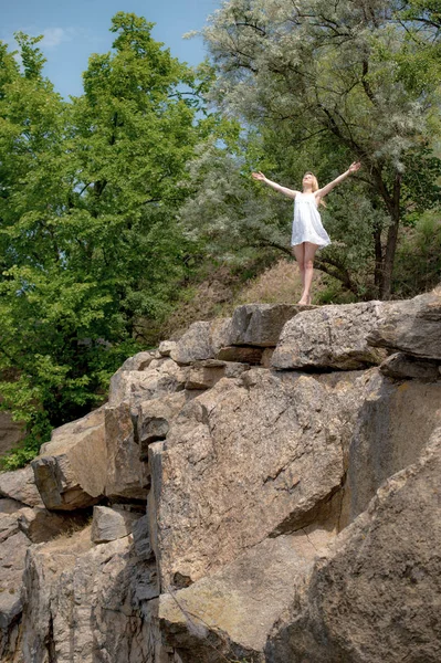 夏の日の崖の端に上げられた手空と若い女性 短い白いドレスを着た女の子 — ストック写真