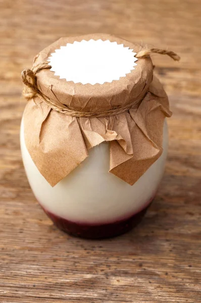 Postre blanco o yogur con mermelada de fresa en una mesa de madera en — Foto de Stock