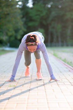Kadın atlet sprint çalıştırmak için hazır. Başlangıç çizgisine runner poz için eğitim bir parkta kızdır.
