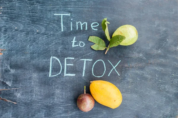 Tijd om de Detox krijt inscriptie op de houten tafel fruit: mango, passievrucht en guave. Gezondheid Concept — Stockfoto