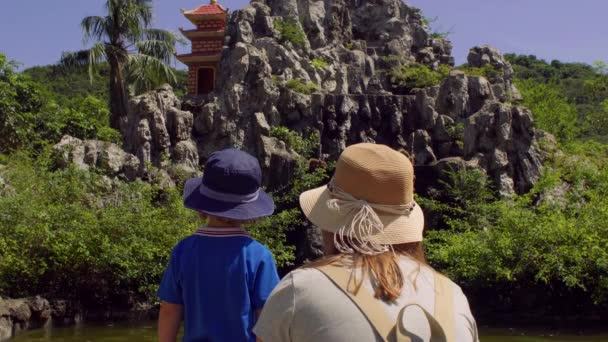 Madre e hijo mirando monos macacos saltando sobre rocas. Monkey Island, Vietnam — Vídeo de stock