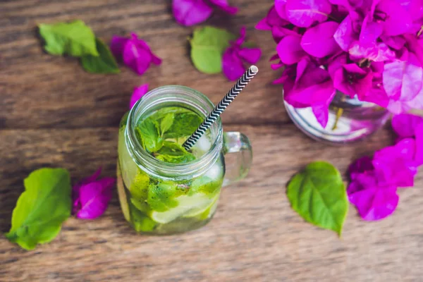 Spring purple flowers and spring mojito drink on an old wooden background — Stock Photo, Image