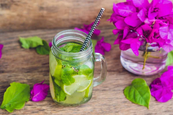 Paarse Lentebloemen en lente mojito drinken op een oude houten achtergrond — Stockfoto