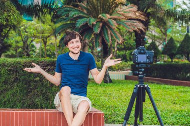 Genç adam blogger kayıt video kamera park önünde