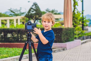Yürümeye başlayan çocuk üzerinde bir kamera bir tripod üzerinde fotoğraf çeker
