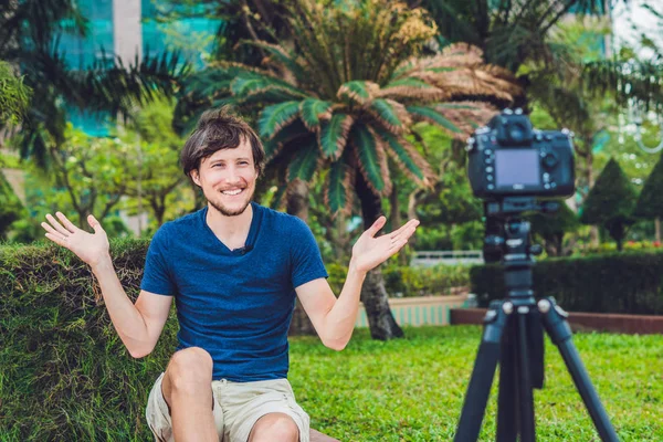 Un jeune blogueur enregistre une vidéo devant la caméra du parc — Photo