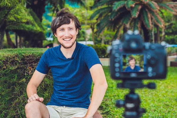 A fiatalember blogger rögzíti a videót a kamera a parkban — Stock Fotó
