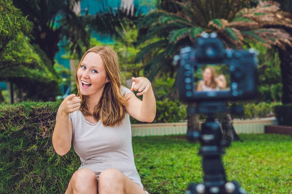 Una giovane blogger sta conducendo il suo video blog davanti alla telecamera del parco. Concetto di blogger — Foto Stock