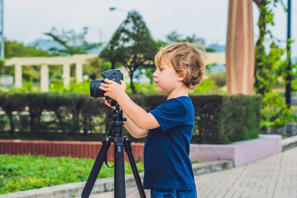 Yürümeye başlayan çocuk üzerinde bir kamera bir tripod üzerinde fotoğraf çeker