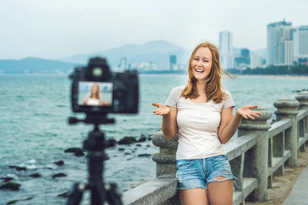 Una joven bloguera dirige su video blog frente a una cámara junto al mar. Concepto de bloguero —  Fotos de Stock