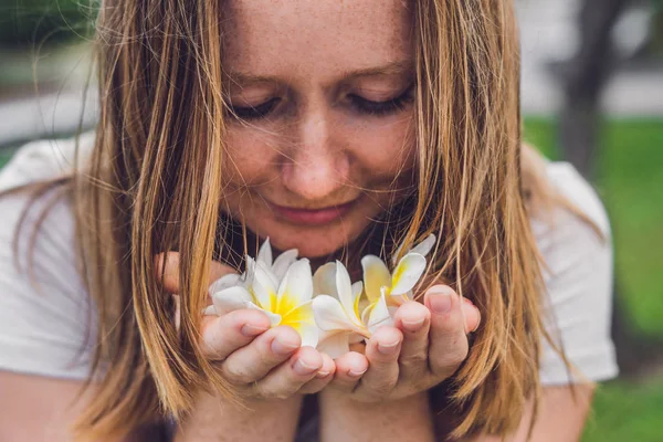 Flores blancas frangipani plumeria en manos femeninas — Foto de Stock