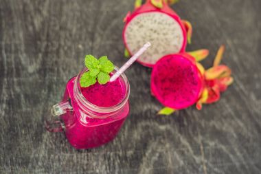 Eski bir ahşap zemin üzerine kırmızı organik dragon meyve smoothies