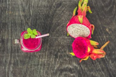 Eski bir ahşap zemin üzerine kırmızı organik dragon meyve smoothies