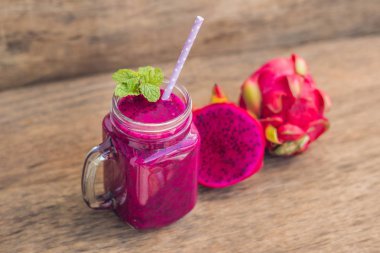 Eski bir ahşap zemin üzerine kırmızı organik dragon meyve smoothies