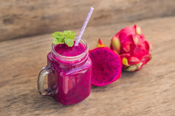 Smoothies of a red organic dragon fruit on an old wooden background — Stock Photo, Image