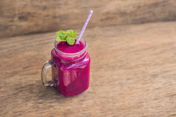 Smoothies of a red organic dragon fruit on an old wooden background — Stock Photo, Image