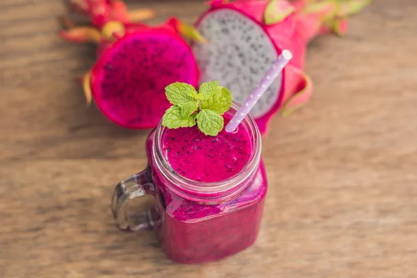 Smoothies of a red organic dragon fruit on an old wooden background — Stock Photo, Image