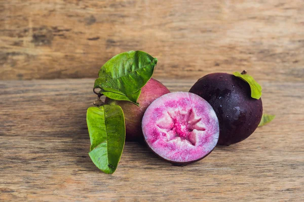 Frutti freschi di cainito Chrysophyllum su fondo legno — Foto Stock