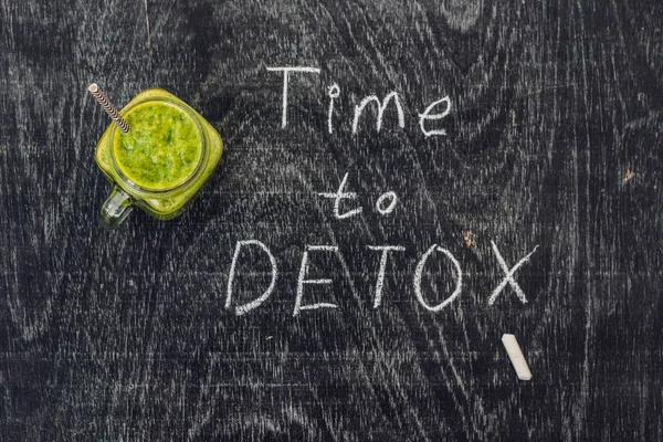 Zeit, Kreideschrift auf dem Holztisch und grüne Smoothies aus Spinat zu entgiften. Konzept für gesunde Ernährung und Sport — Stockfoto