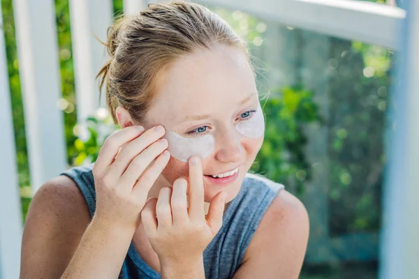 Portrait of Beauty Red-haired woman with eye patches showing an effect of perfect skin. Spa Girl — Stock Photo, Image