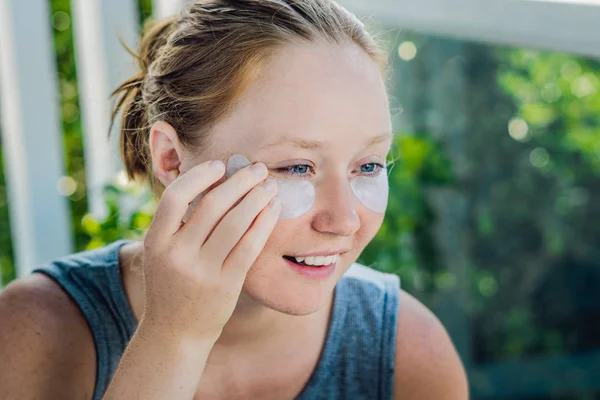 Portrait of Beauty Red-haired woman with eye patches showing an effect of perfect skin. Spa Girl — Stock Photo, Image