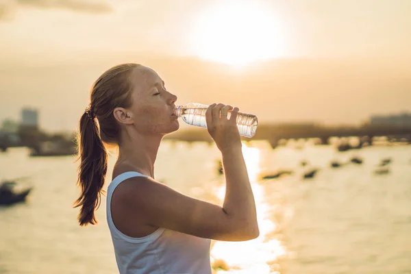 Deportiva mujer bebiendo agua al aire libre en día soleado — Foto de Stock