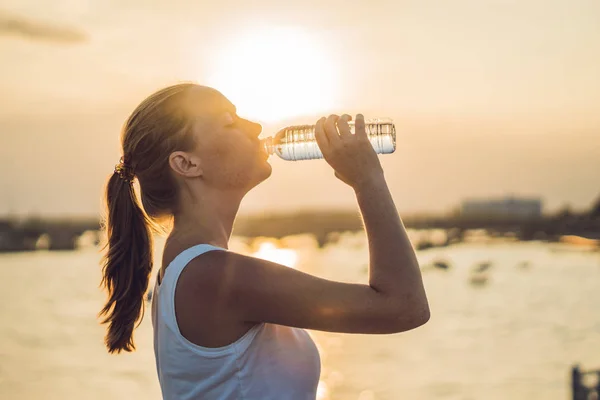 Sporty woman drinking water outdoor on sunny day — Stock Photo, Image