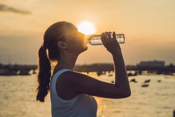 Deportiva mujer bebiendo agua al aire libre en día soleado — Foto de Stock