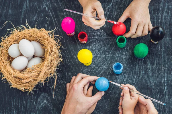 Frohe Ostern: Mutter, Vater und Sohn bemalen Ostereier. glückliche Familie bereitet sich auf Ostern vor — Stockfoto