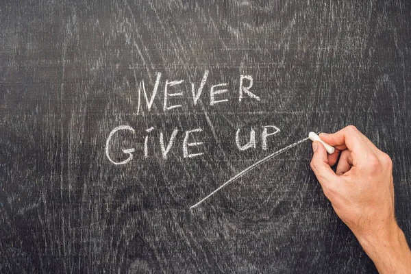 Never give up words written on the chalkboard — Stock Photo, Image