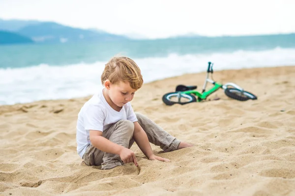Активный блондин мальчик и велосипед у моря. Ребенок мечтает и веселится в теплый летний день. игры на открытом воздухе для детей. Концепция балансировки велосипедов — стоковое фото