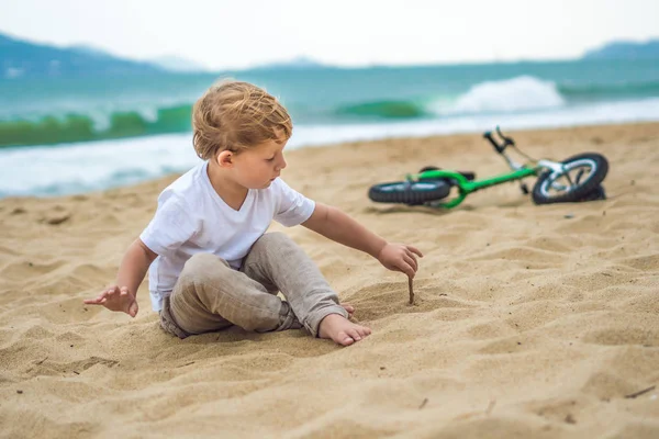 Ragazzo biondo attivo e bicicletta vicino al mare. Bambino bambino che sogna e si diverte nella calda giornata estiva. giochi all'aperto per bambini. Concetto Balance bike — Foto Stock