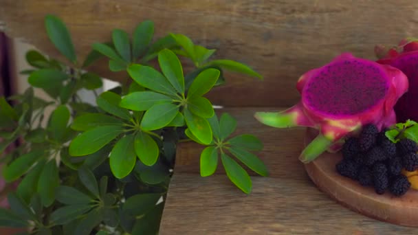 Fruta de dragón en rodajas y mango sobre un fondo de madera viejo — Vídeo de stock