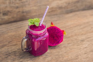 Eski bir ahşap zemin üzerine kırmızı organik dragon meyve smoothies