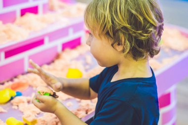 Okul öncesi Kinetik kumla oynayan çocuk. İnce motor kavramı geliştirilmesi. Yaratıcılık oyun kavramını