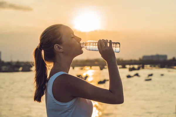 Sporty woman drinking water outdoor on sunny day — Stock Photo, Image