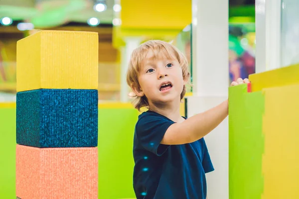 Niño feliz jugando en el interior con grandes bloques de construcción de plástico — Foto de Stock