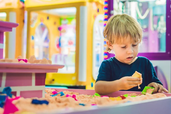 Junge spielt im Vorschulalter mit kinetischem Sand. die Entwicklung eines feinmotorischen Konzepts. Spielkonzept Kreativität — Stockfoto