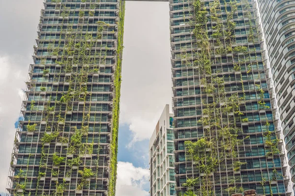 KUALA LUMPUR, MALAYSIA - 24 FEBRUARY 2017: Eco architecture. Green skyscraper building with plants growing on the facade. Ecology and green living in city, urban environment concept. Park in the sky — Stock Photo, Image